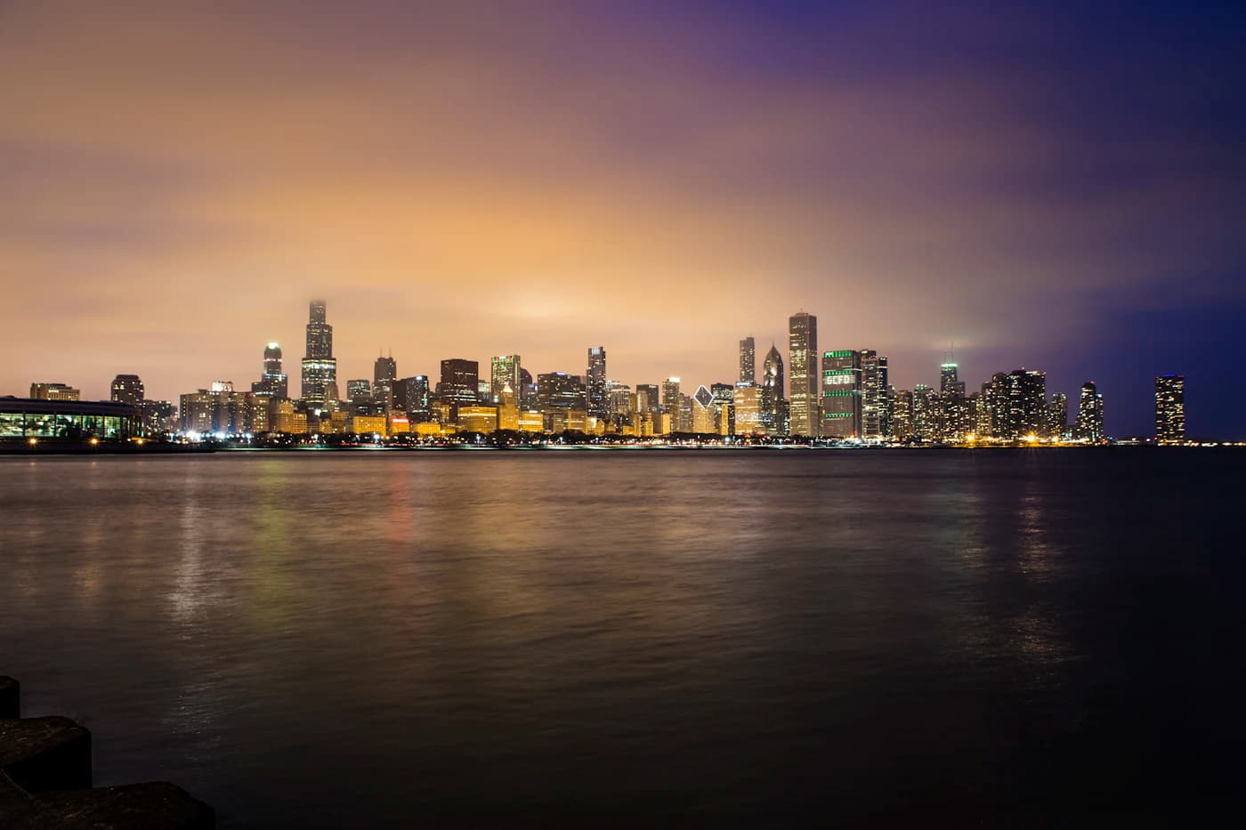 Chicago skyline at golden hour, reflected in the lakefront.