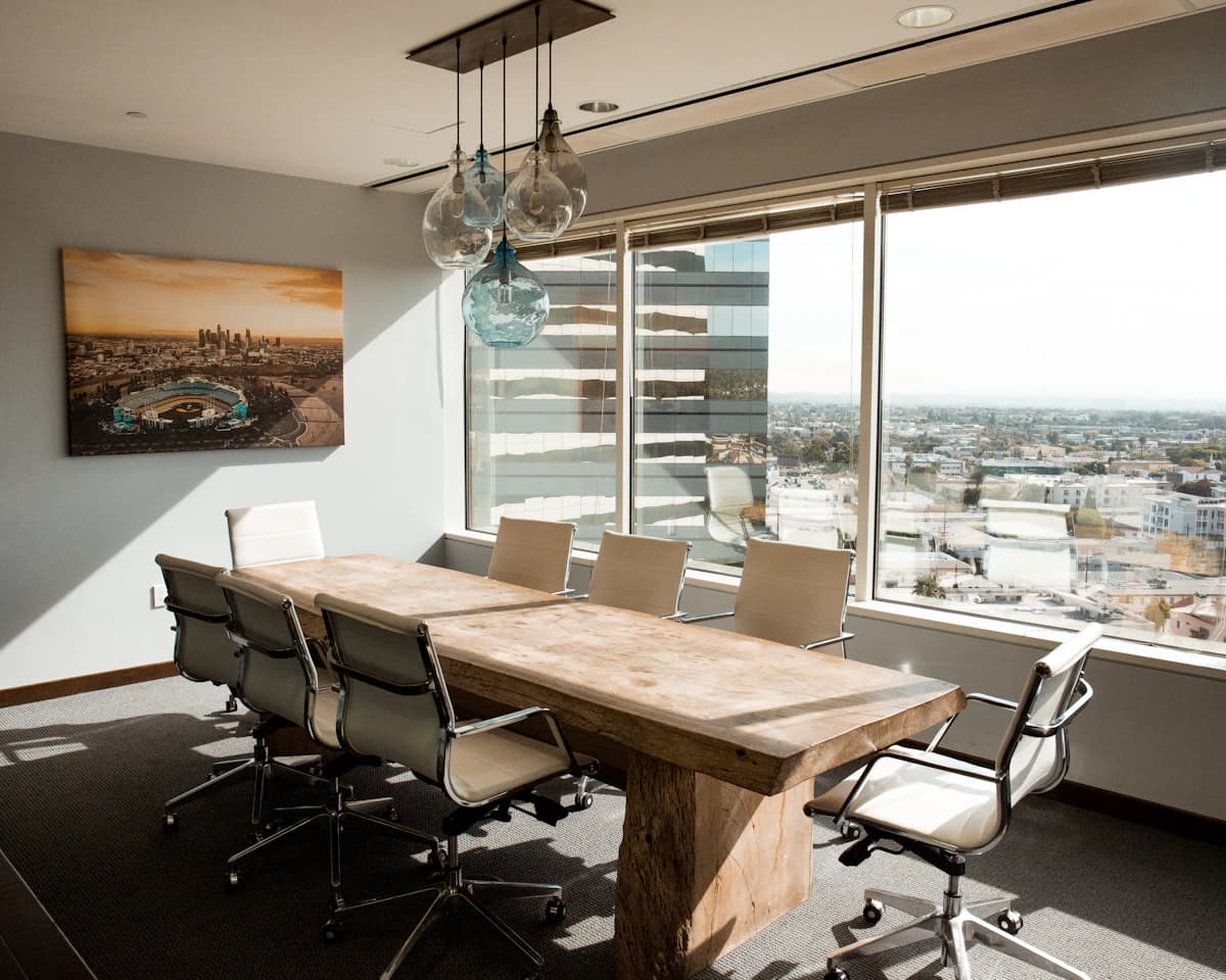 A refined boardroom with a wood-slab table and a city view, where the payroll burden is handed off.