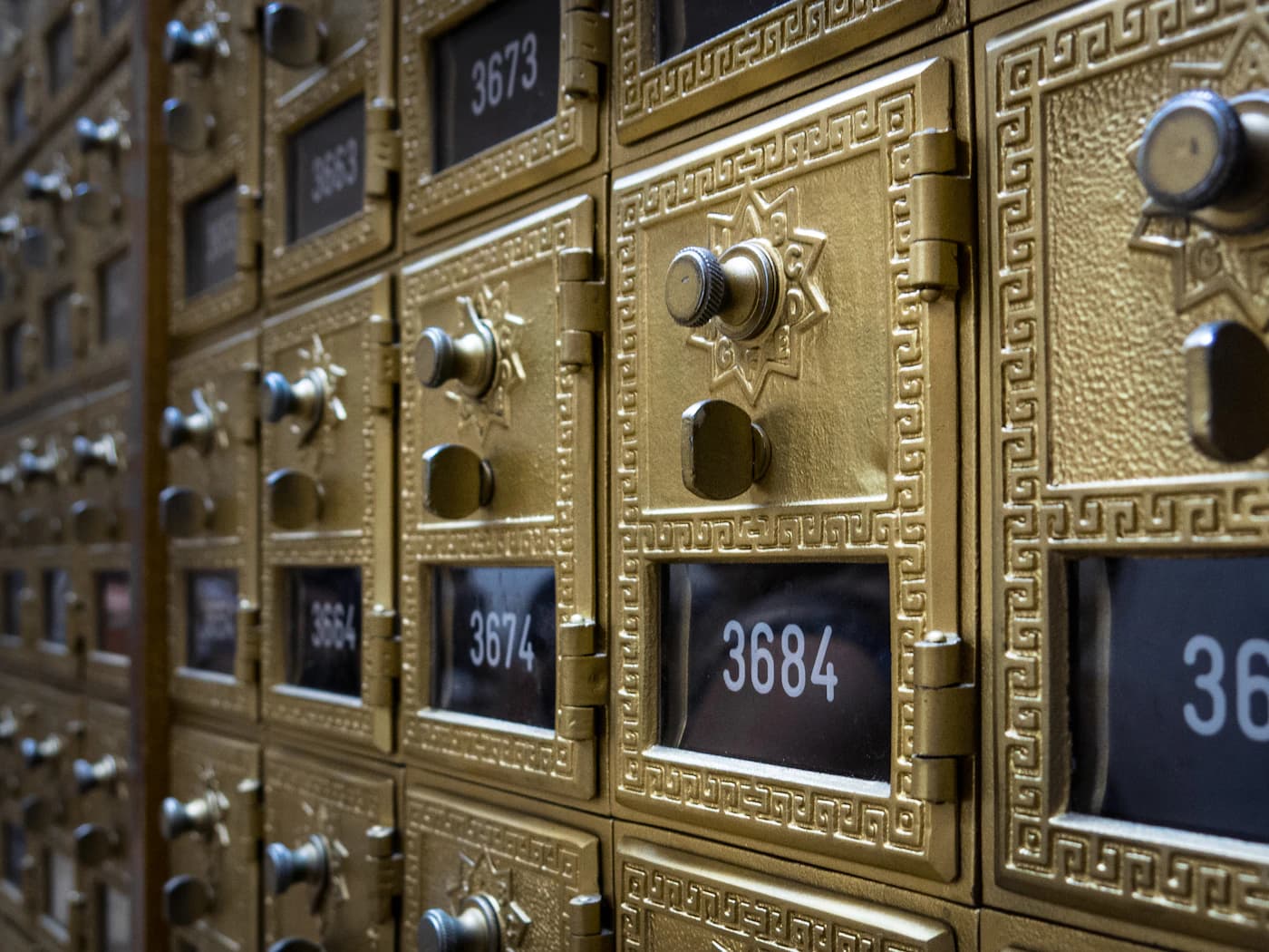 A wall of brass post boxes.