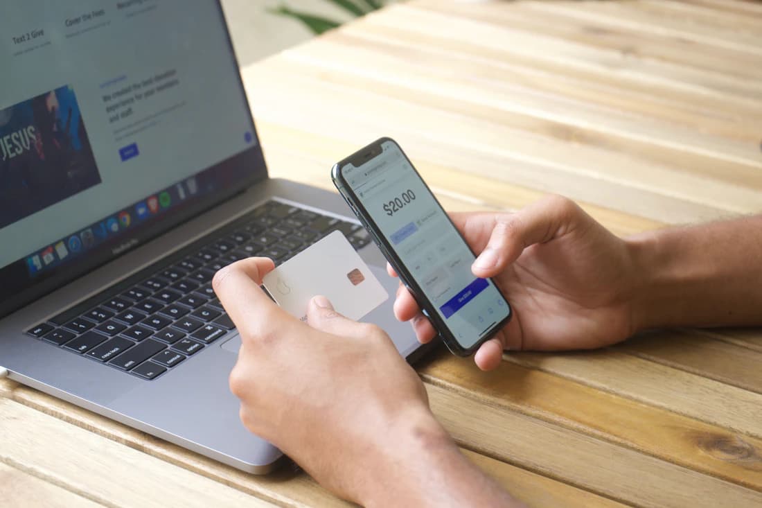 A card payment made on a phone beside a laptop.