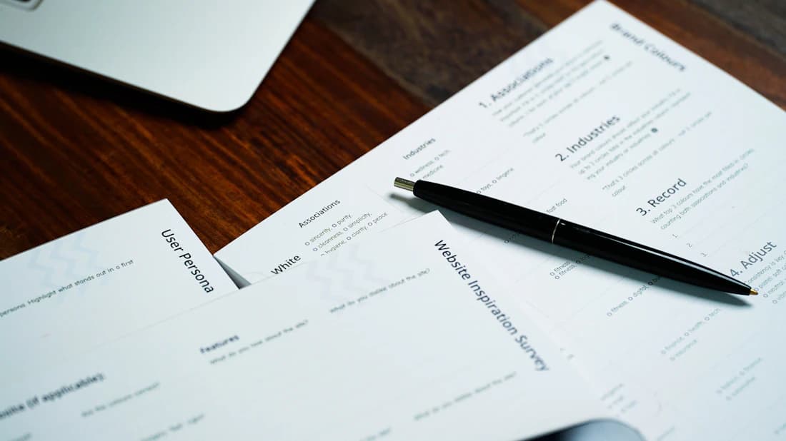 State renewal forms laid out with a pen on a desk.