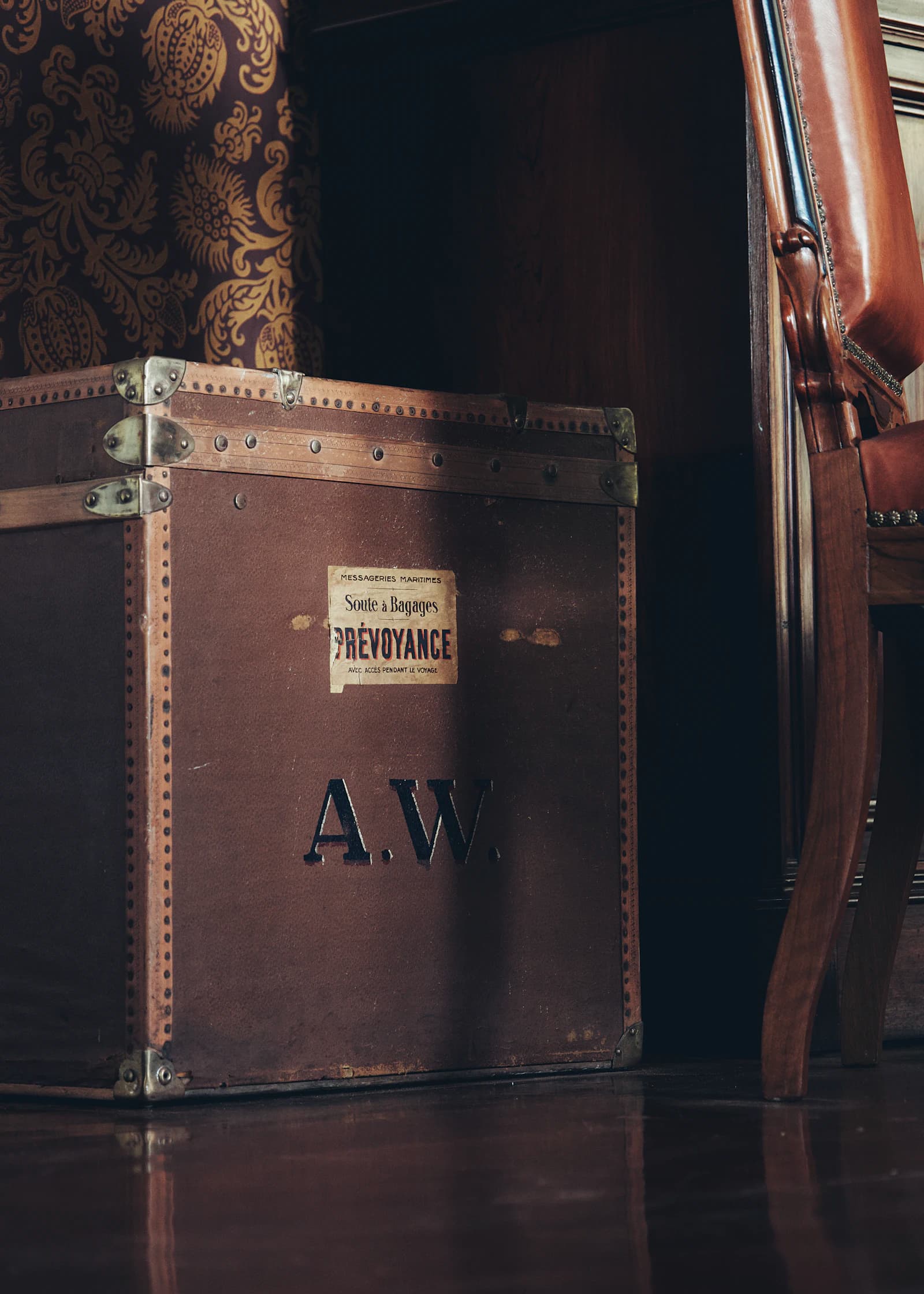 An antique steam trunk stencilled with a founder's monogram.