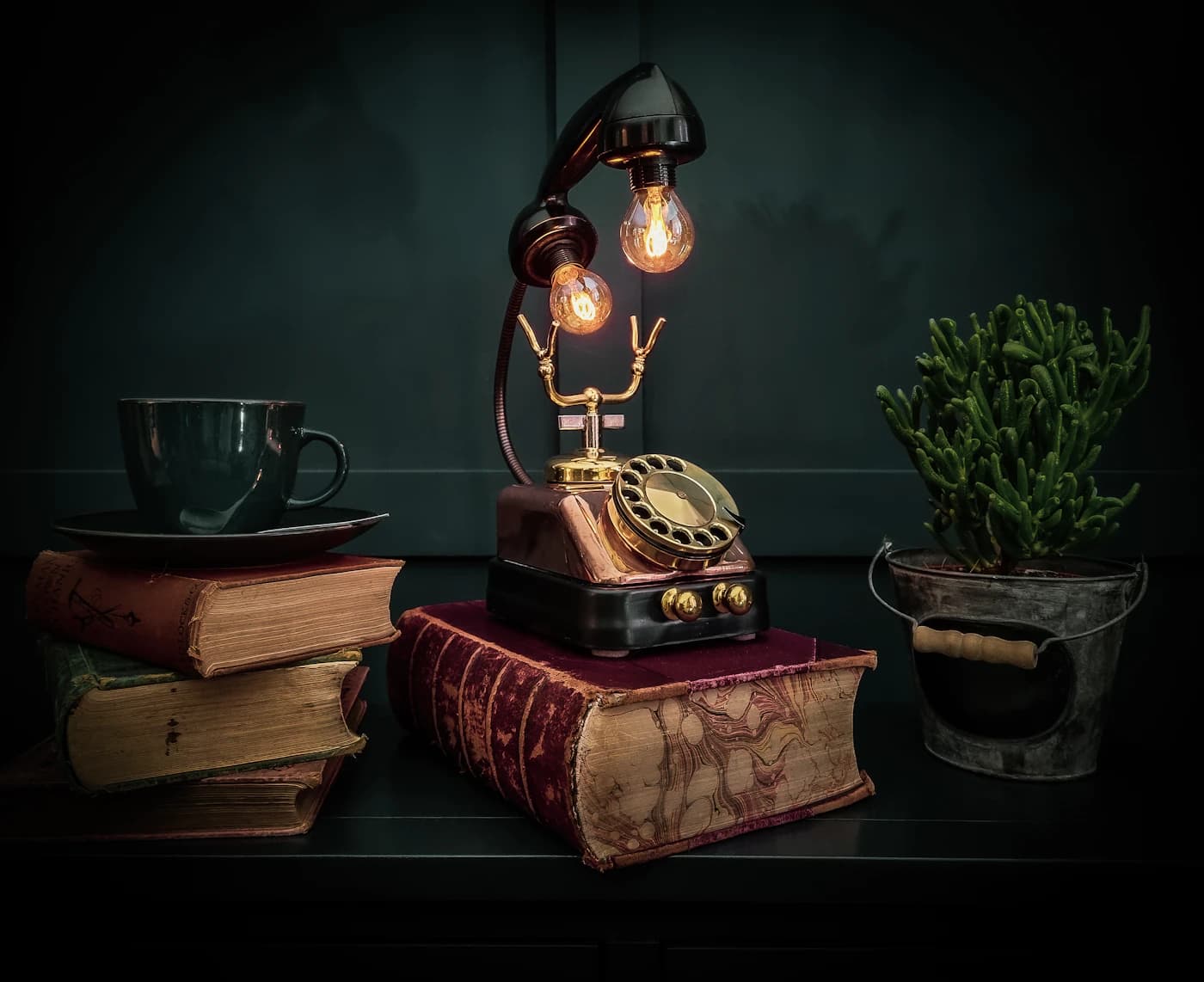 An antique telephone beside stacked books.
