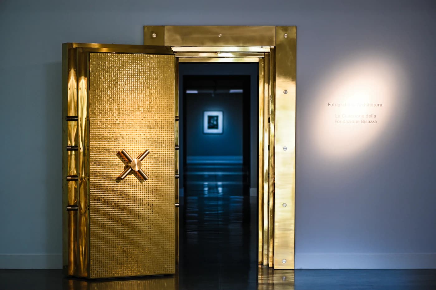 An open golden vault door leading into a dark hallway.