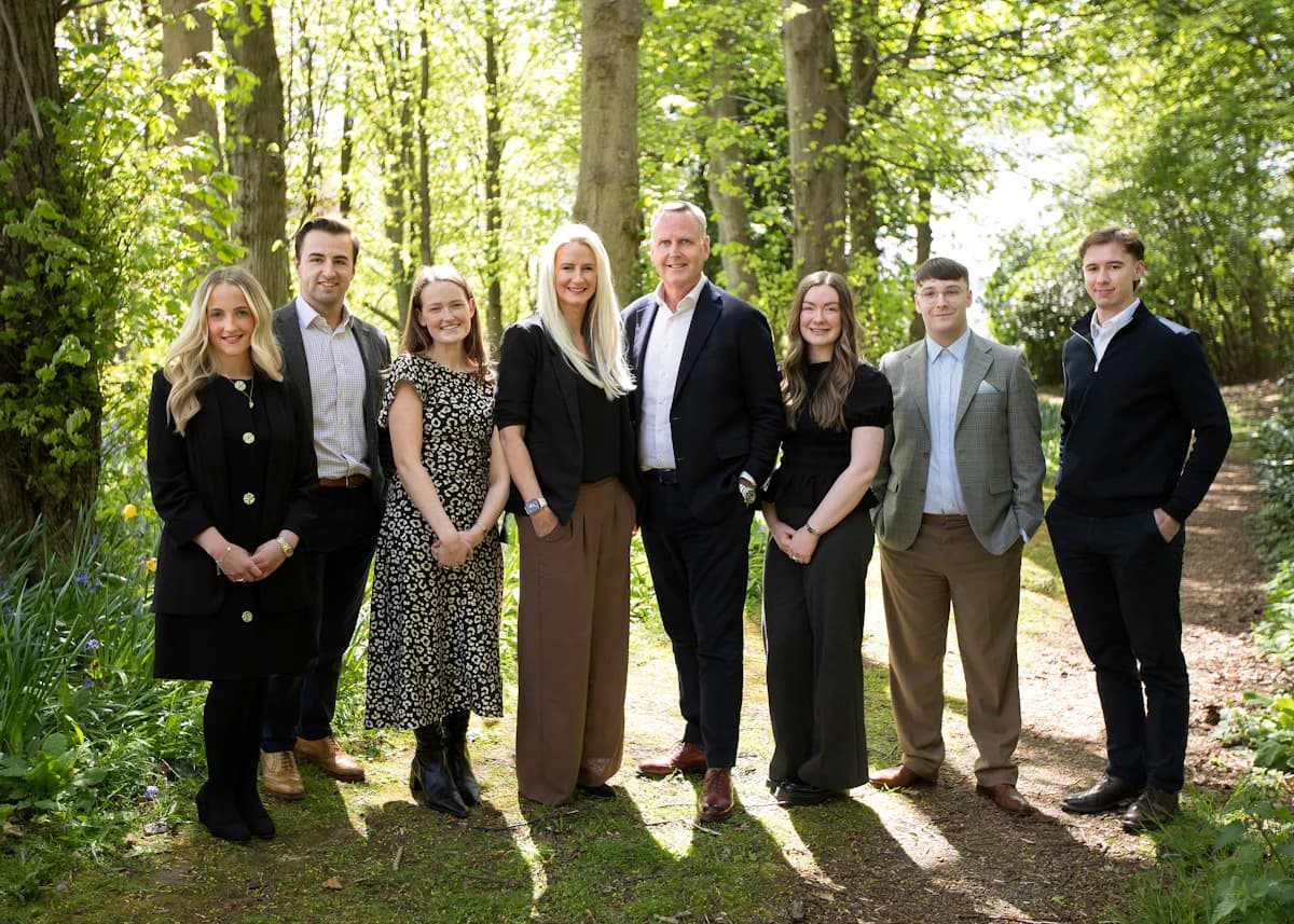 A growing team gathered together in warm light, the people a scaling payroll carries.